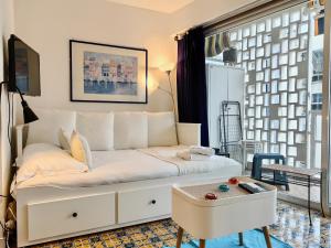 een woonkamer met een witte bank en een tafel bij Studio Royal Lux by Booking Guys in Nice
