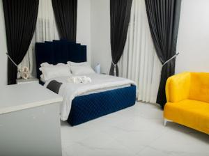1 dormitorio con 1 cama azul y 1 silla amarilla en The Duch Apartments, en Lagos
