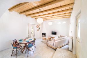 Una sala de estar con una mesa y sillas y un sofá. en Villa Theona with private pool, en Pitsidia
