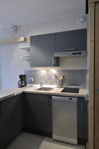 een kleine keuken met een wastafel en een fornuis bij Appartement avec ascenseur LA DÉFENSE in Courbevoie
