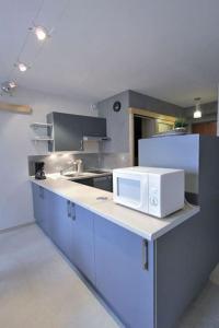 una cocina con microondas blanco en una encimera en Appartement avec ascenseur LA DÉFENSE en Courbevoie