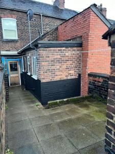 a brick building with a garage with a door at SkylinesAirbnb in Stoke on Trent