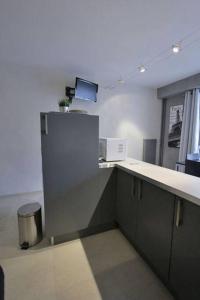 an empty room with a counter and a refrigerator at Appartement avec ascenseur LA DÉFENSE in Courbevoie