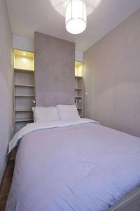 een slaapkamer met een groot wit bed. bij Appartement avec ascenseur LA DÉFENSE in Courbevoie