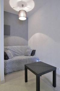 a room with a bed and a table and a lamp at Appartement avec ascenseur LA DÉFENSE in Courbevoie