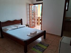 sypialnia z łóżkiem z ręcznikami w obiekcie Pousada Sol da Lagoinha w mieście Ubatuba
