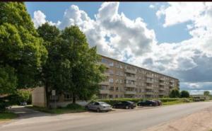 um grande edifício com carros estacionados num parque de estacionamento em Jalaka, Nice 2-bedroom apartment - 1 big bed - 2 single bed em Tartu