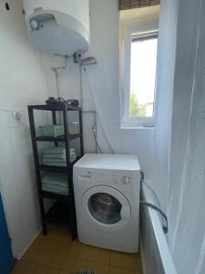 uma máquina de lavar roupa na casa de banho com uma janela em Rodinný apartmán Výrov em Nové Město nad Metují