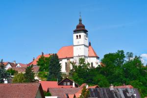 uma grande igreja branca com um campanário no topo dos telhados em Rodinný apartmán Výrov em Nové Město nad Metují