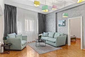 - un salon avec deux chaises et un canapé dans l'établissement Bucharest Ultracentral Apartment, à Bucarest