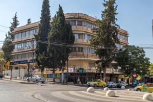 a large building with cars parked in front of it at Antika Amman Hotel in Amman