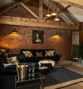 TOFY (The Old Forge York) في يورك: غرفة معيشة مع أريكة وجدار من الطوب
