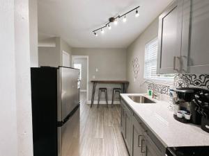 a kitchen with a stainless steel refrigerator and a table at Rustic Retreats Cozy 1BR for 4 guests minutes from Las Olas in Fort Lauderdale +4 photos