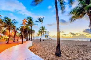 a beach with palm trees and a sunset at Rustic Retreats Cozy 1BR for 4 guests minutes from Las Olas in Fort Lauderdale