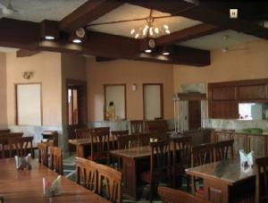 a dining room with tables and chairs in a restaurant at Ananda Krishna Van in Vrindāvan