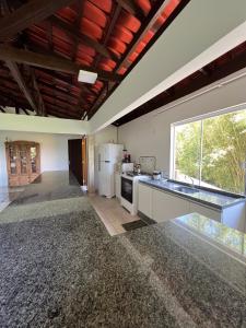 Il dispose d'une grande cuisine avec un réfrigérateur et une fenêtre. dans l'établissement Pousada Sabores do Mar Laranjeiras, à Balneário Camboriú