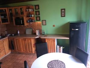uma cozinha com um frigorífico e uma mesa com cadeiras em Chalupa Kociánka em Loučná nad Desnou