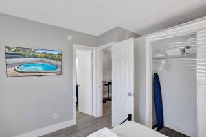 een kamer met een bed en een schilderij aan de muur bij Rustic Retreats Cozy 1BR For 4 Guests Minutes From Las Olas in Fort Lauderdale