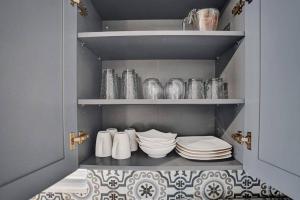 eine Pantryküche mit Tellern und Geschirr auf Regalen in der Unterkunft Rustic Retreats Cozy 1BR For 4 Guests In The Heart Of Fort Lauderdale in Fort Lauderdale