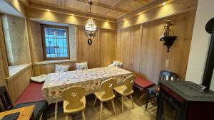 a dining room with a table and chairs at Casa Vettori in San Niccolò Comèlico