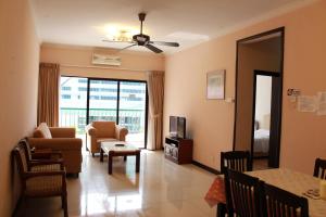 a living room with a couch and a tv at Marina Court Kota Kinabalu- Bigger Group Stay Together- 5 & 6 Bedroom Apartments in Kota Kinabalu