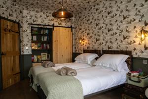 dos animales de peluche sentados en dos camas en un dormitorio en TOFY (The Old Forge York), en York