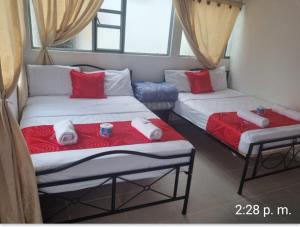 2 Betten in einem Zimmer mit roten und weißen Decken in der Unterkunft HOTEL ISMAEL de la VILLA in Tinjacá