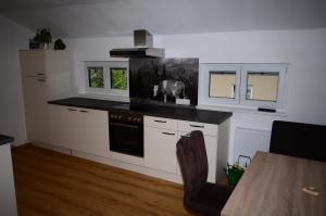 a kitchen with white cabinets and a black counter top at Haus Jakob in Filzmoos