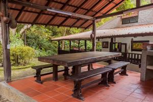 una mesa de madera y bancos en un patio en Las Margaritas - La Tigrera, Minca, en Santa Marta