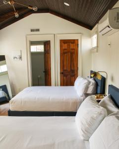 Un dormitorio con dos camas y una puerta de madera. en Guesthouse Charleston SOUTH 82 B, en Charleston