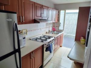a kitchen with wooden cabinets and a stove top oven at Disfruta de la ciudad en un espacio tranquilo! in Guadalajara