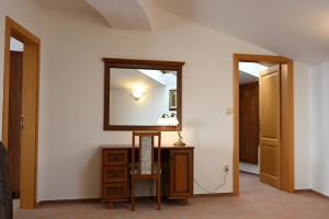 a hallway with a mirror and a dresser with a lamp at Hotel Eufória in Nová Lesná