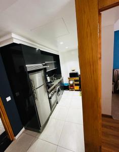 a kitchen with a black refrigerator and a white tile floor at Tazi studio 2 in Casablanca