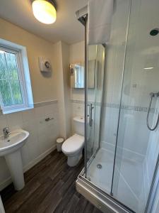 y baño con ducha, aseo y lavamanos. en Chervil House by YourStays en Newcastle under Lyme