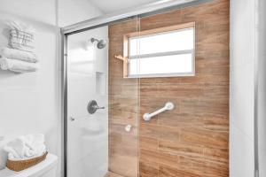 baño con ducha y puerta de cristal en Waves Beach Town Studio Apartment en Pompano Beach