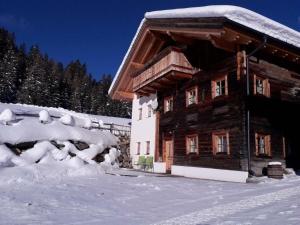una cabaña de madera en la nieve con árboles nevados en Berg Apart Anna, en Zaunhof
