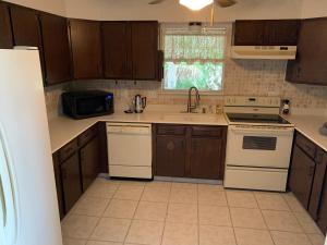 a kitchen with wooden cabinets and white appliances at Stay near Beautiful San Felipe Creek. in Del Rio