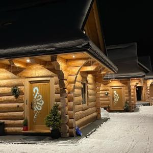 een blokhut in de sneeuw 's nachts bij Domek drewniany w górach Jacuzzi & Balia - Osada Chełm in Stróża