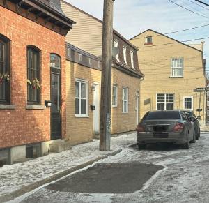 a car parked in a street next to buildings at Coin tranquille en pleine ville in Quebec City