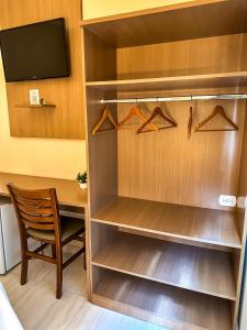 a walk in closet with a table and a chair at Hotel Stelati in Jaguariúna