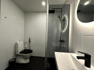 uma casa de banho com um WC, um lavatório e um chuveiro em Kotimaailma Apartments#4 - Moderni, tilava kaksio keskustassa em Seinäjoki