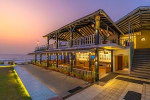 a building with a restaurant on the beach at night at La Cabana Beach & Spa, By Ashvem Beach in Mandrem
