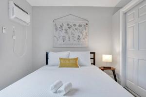 a bedroom with a white bed with two towels on it at Rustic Retreats Beachy 1BR for 4 guests in the heart of Fort Lauderdale in Fort Lauderdale