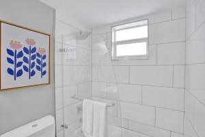 a white bathroom with a shower and a window at Rustic Retreats Beachy 1BR for 4 guests in the heart of Fort Lauderdale in Fort Lauderdale