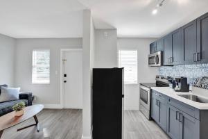 a kitchen with blue cabinets and a black refrigerator at Rustic Retreats Beachy 1BR for 4 guests in the heart of Fort Lauderdale in Fort Lauderdale