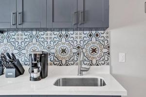 a kitchen with a sink and a tile wall at Rustic Retreats Beachy 1BR for 4 guests in the heart of Fort Lauderdale in Fort Lauderdale +14 photos