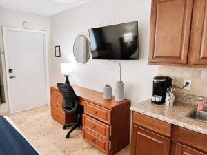 cocina con escritorio con silla y fregadero en Waves Beach Town Cozy Studio Apartment en Pompano Beach