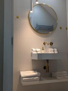 a bathroom with a sink and a mirror and towels at GREATER LONDON APARTMENT in London