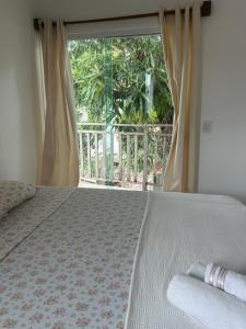 - une chambre avec un lit et une grande fenêtre dans l'établissement Suítes Modernas no Centro da Praia da Pipa, à Pipa