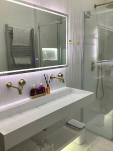 een witte badkamer met een wastafel en een spiegel bij GREATER LONDON APARTMENT in Londen